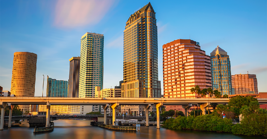 A wide shot of the Tampa Bay skyline, including a highway and multiple buildings in the background.