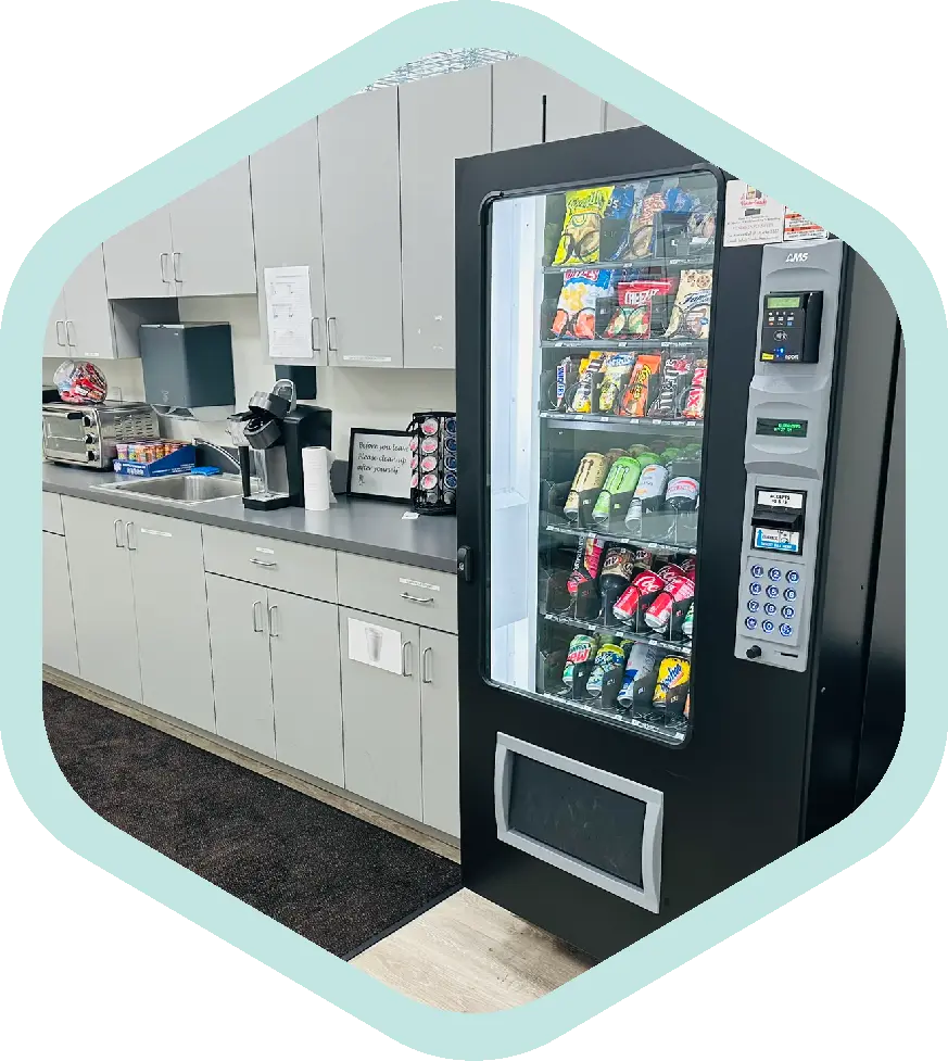 trusted-side An office vending machine stocked with snacks and drinks for coworkers.